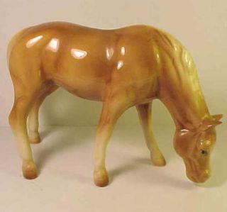 this is a ceramic palomino coloured horse grazing the horse is a 