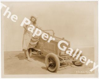 Photograph of Dolores Costello with a race car