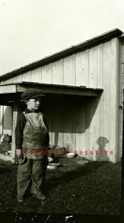 NEGATIVE boy holding a claw hammer on farm, lumber store apron